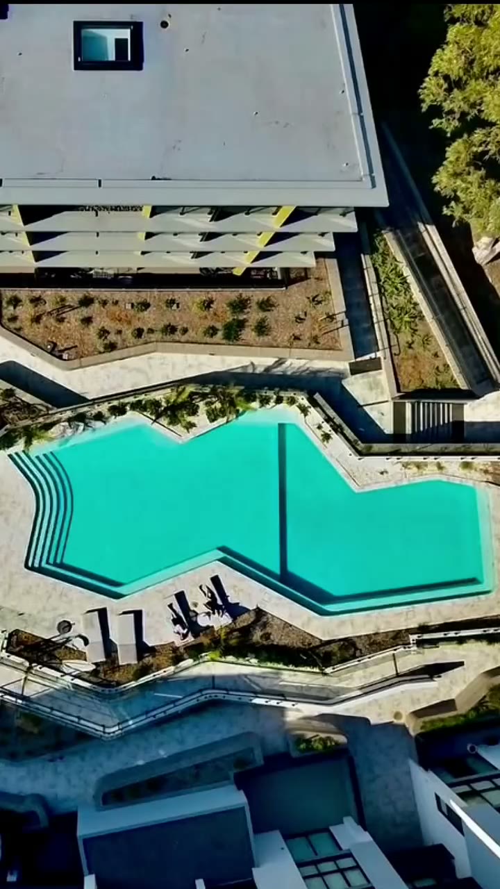 An aerial view of a large commercial pool on a multi level development